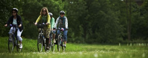 Women cycling through park